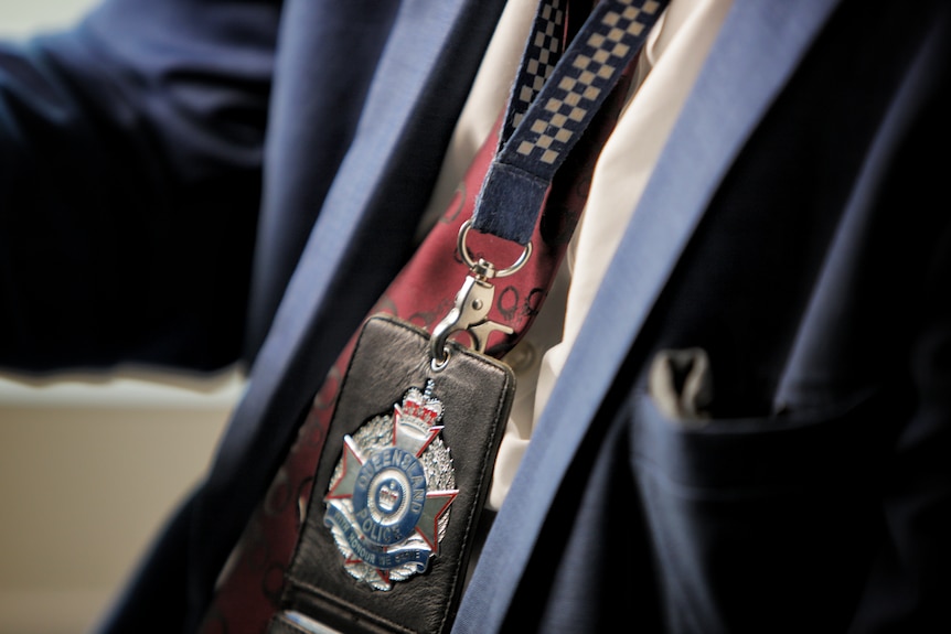 a close-up of a police badge on a lanyard being worn by a detective