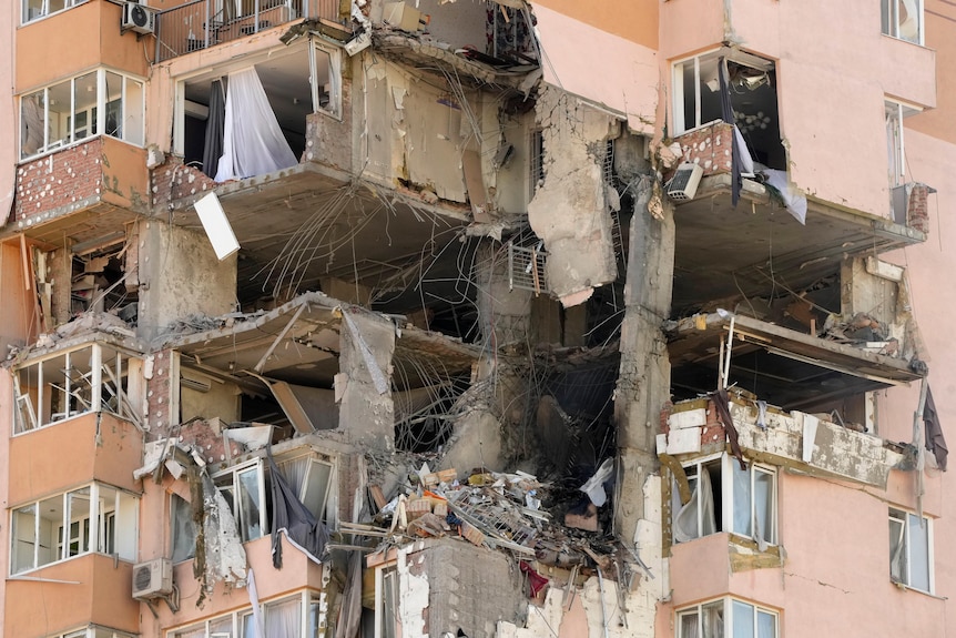 A partially destroyed apartment building is seen after a rocket attack that hit several levels of flats.