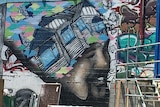A mural of a man with a house on his head is painted on a wall in Christchurch, New Zealand.