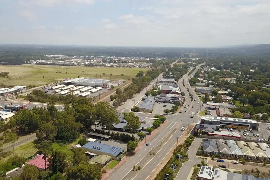 An aerial photo of Byford town centre including the main road and green paddocks.