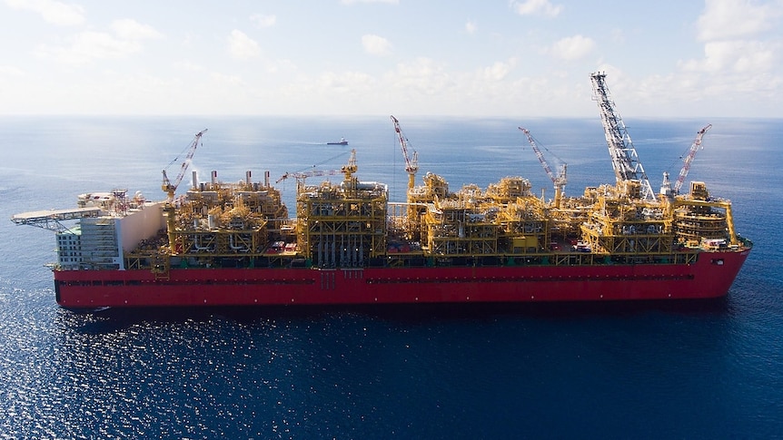 Aerial shot of giant floating gas processing plant on a shimmering sea