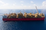 Aerial shot of giant floating gas processing plant on a shimmering sea