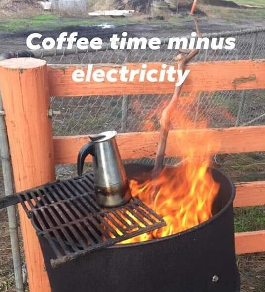 A coffee pot sits on top of a grill plate over a fire