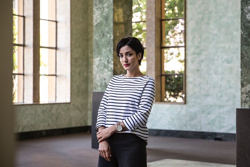 Colour photo of artist Hoda Afshar standing in hall with marbled walls in the Museum of Contemporary Art.