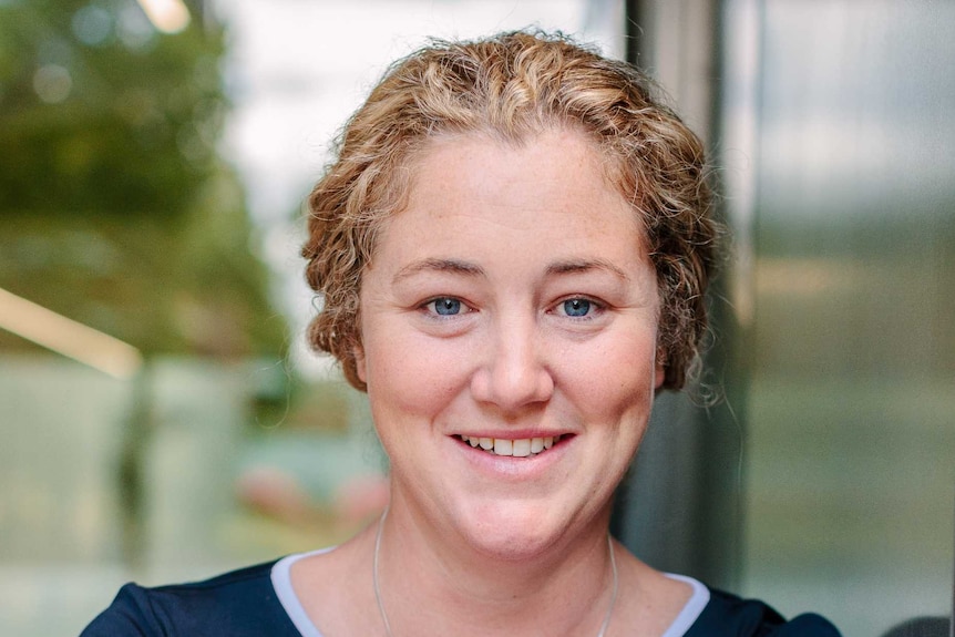 A picture of Sarah Anderson wearing a blue top and necklace, smiling at the camera.