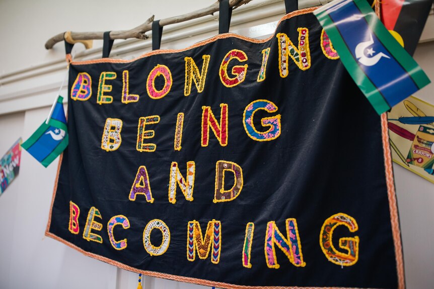 A colourful sign which reads belonging, being and becoming