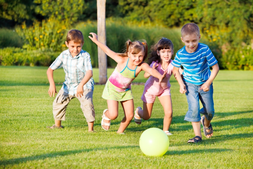 Kids playing outside with a ball.