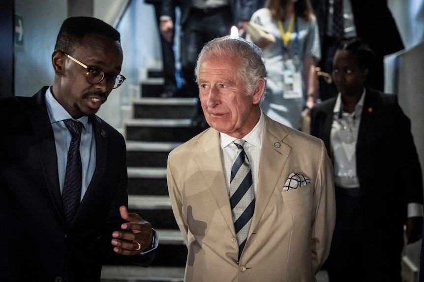 Prince Charles speaks to a man during a visit to the Kigali Genocide Memorial Rwanda.