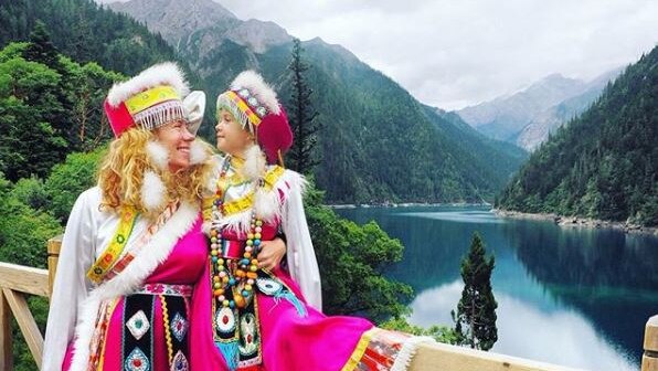 Mother and daughter dressed in pink tradition costume in Jiuzhaigou.