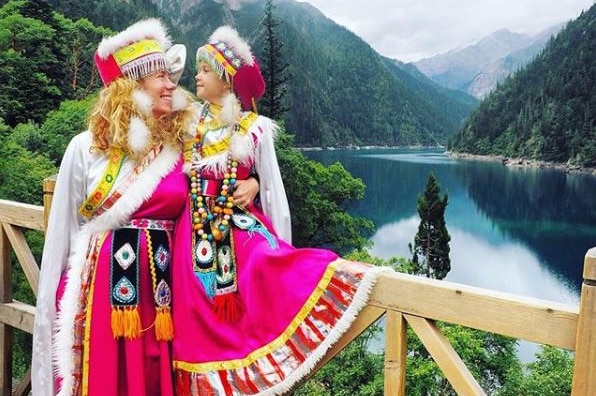 Mother and daughter dressed in pink tradition costume in Jiuzhaigou.