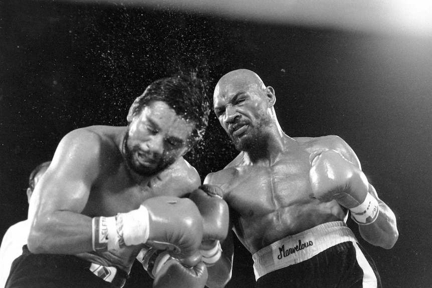 Marvin Hagler hits Roberto Duran, who bends down and has sweat flying off him