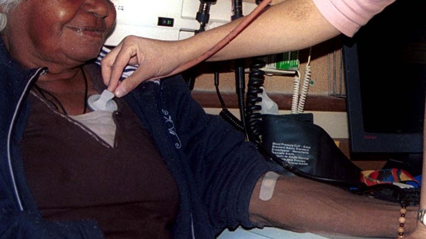 A doctor treats an elderly Aboriginal woman in a clinic