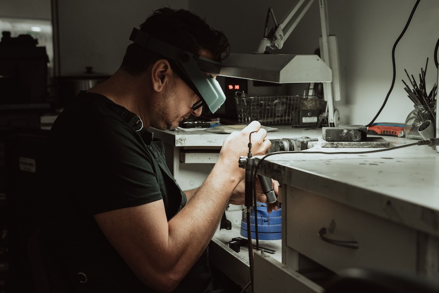 Jeweller Rohan Milne works on a piece.