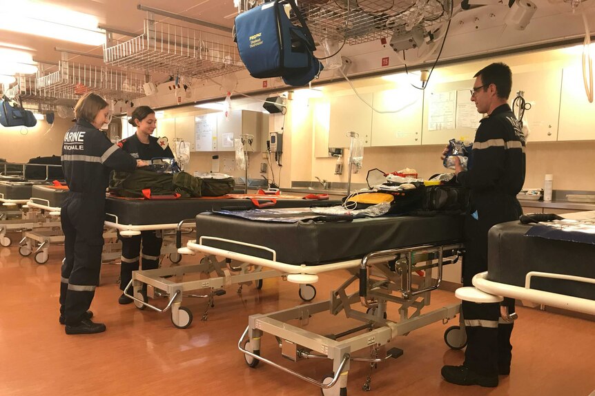 Medics on board French warship Mistral stand with first aid kits on beds in the ship's hospital wing.
