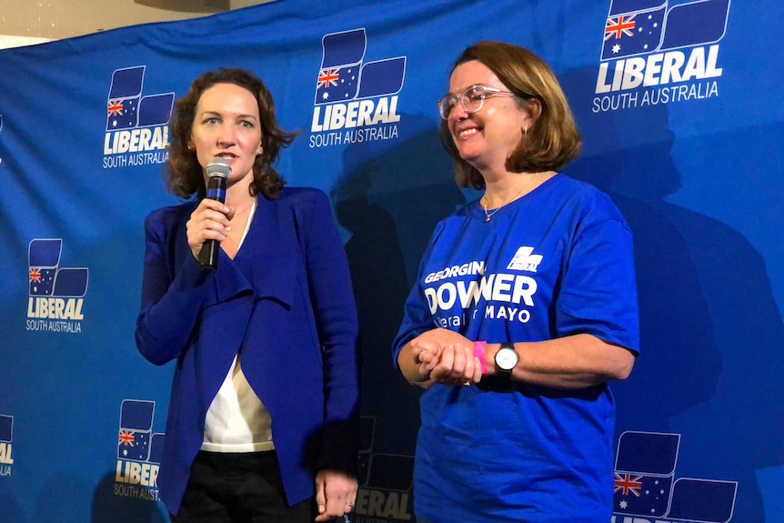 Georgina Downer holds a microphone and delivers her concession speech.