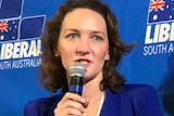 Georgina Downer holds a microphone and delivers her concession speech.