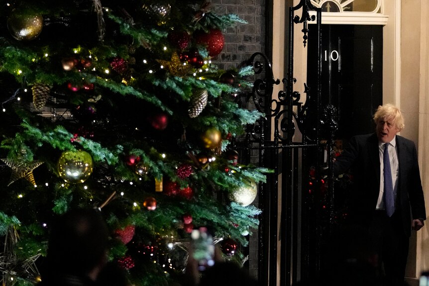 Boris Johnson은 10 Downing Street 밖에 있는 크리스마스 트리 옆에 서 있습니다.