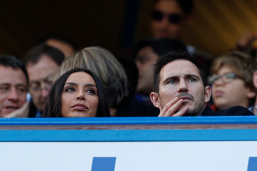 man and woman watch on in sport stand