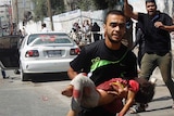 Man runs with child after Gaza air strike