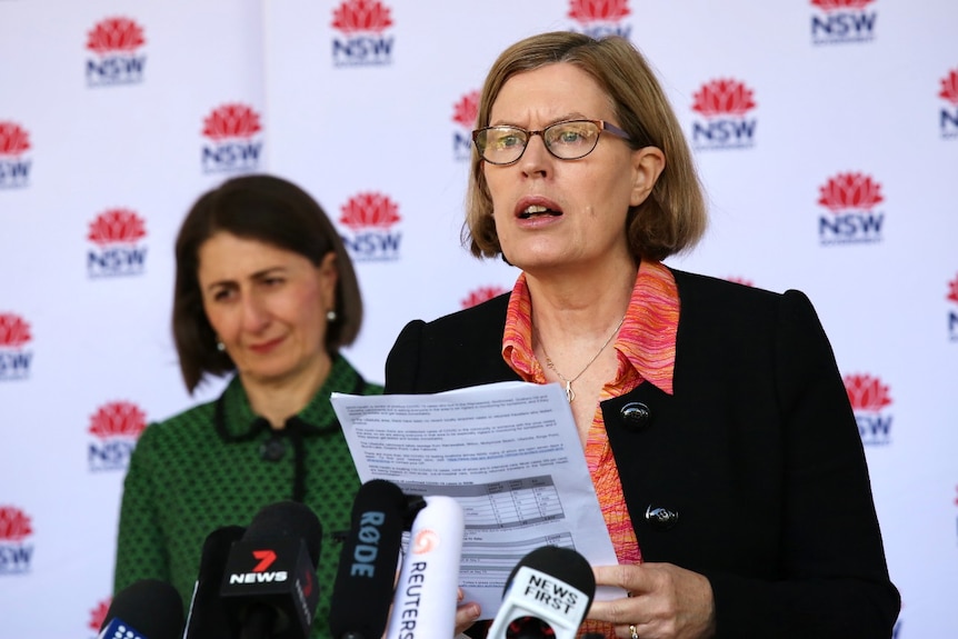 Two women speak at a podium.