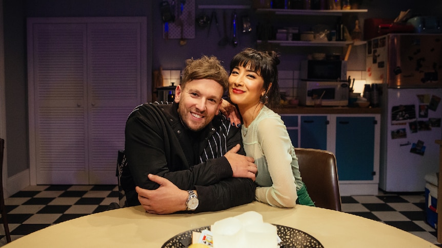 Dylan Alcott wearing black sweater, and Linda Marigliano dressed in green, sitting at a kitchen table