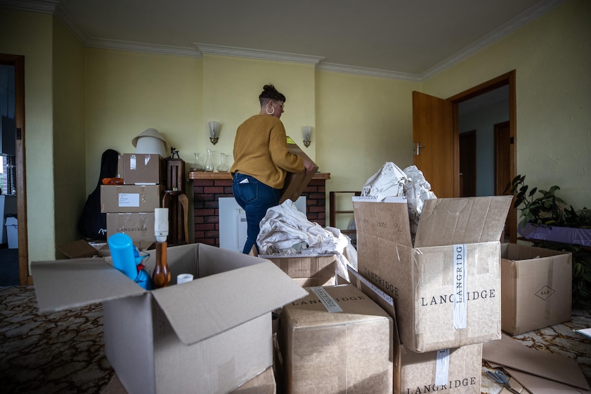 A woman with packing boxes in the foreground.