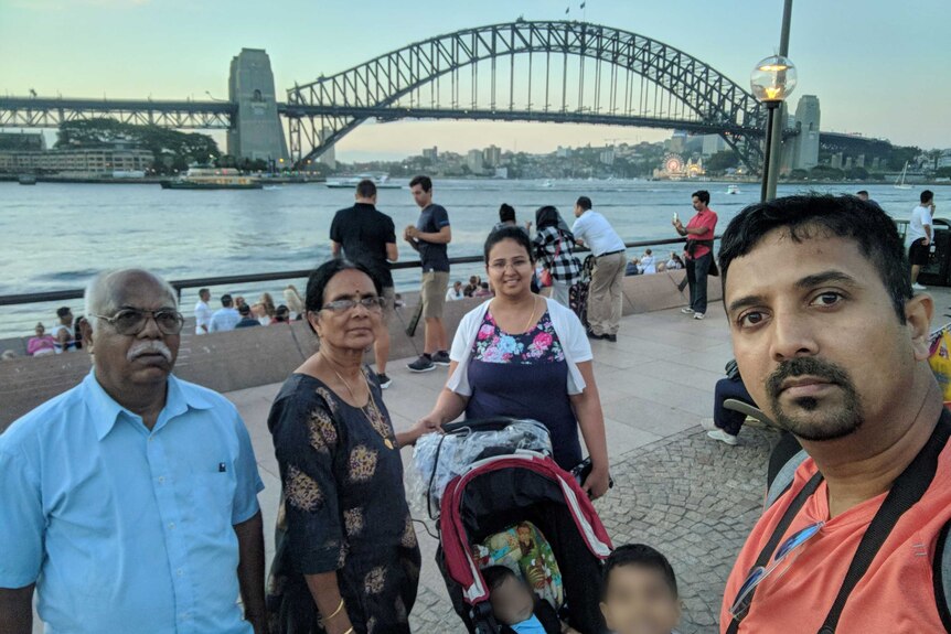Srihari and his family, including his parents, near Sydney Harbour with the Harbour Bridge beyond