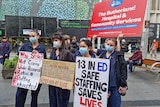 Nurses hold signs while protesting