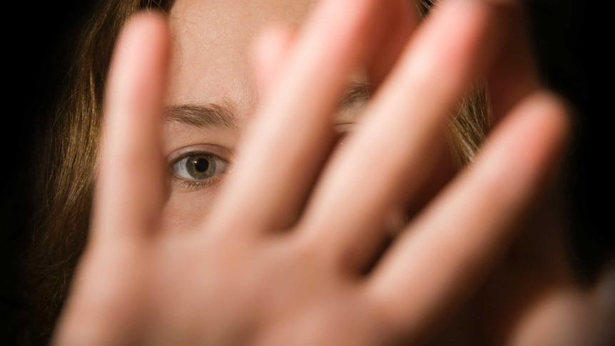 A woman's hands in front of her face