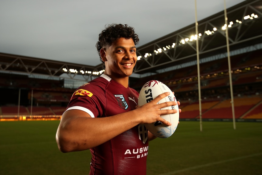 Selwyn Cobbo posando con una camiseta de los Queensland Maroons.