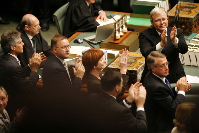 Políticos vestidos de noche oscuros, incluidos Julia Gillard, Wayne Swan y Kevin Rudd, aplauden frente a la Cámara de los Comunes.