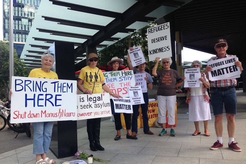 Refugee advocates wearing black armbands