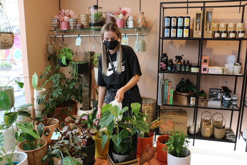 Kaitlan Turner standing among plant pots in a shop