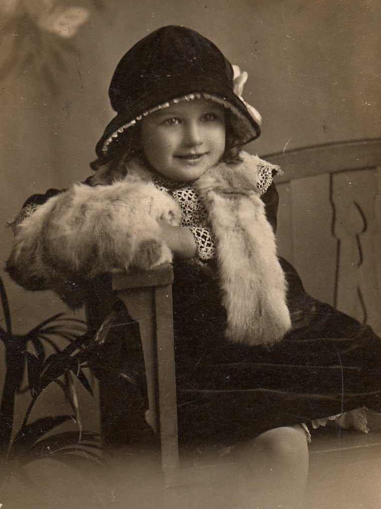 A black and white photo of a young girl in a cloche hat.