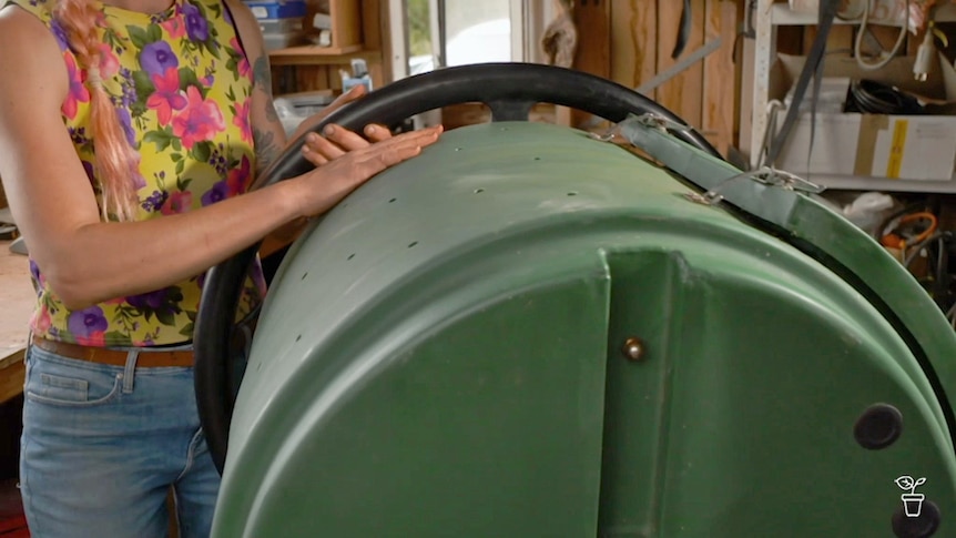 Compost tumbler with holes drilled into it.