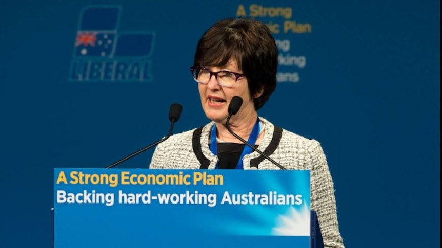 A lady with short dark hair speaking at a Liberal Party lectern
