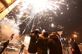 People watch fireworks explode on the streets of Beijing.