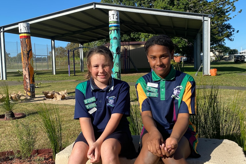 Students Kiarra-Lee Thornton and Nandee Pedro sit on a sandstone block in the new garden