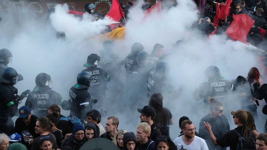 Smoke is seen as police clash with protesters.