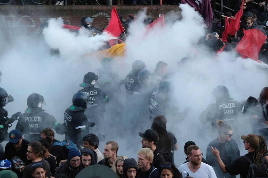 Smoke is seen as police clash with protesters.
