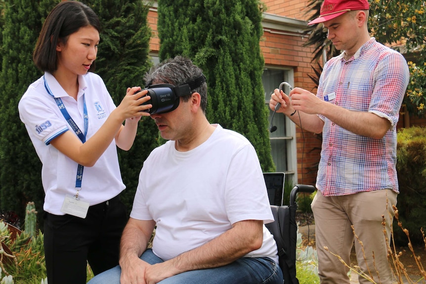 Study participant Steven Ribarich is fitted with virtual reality goggles for an online singing session.