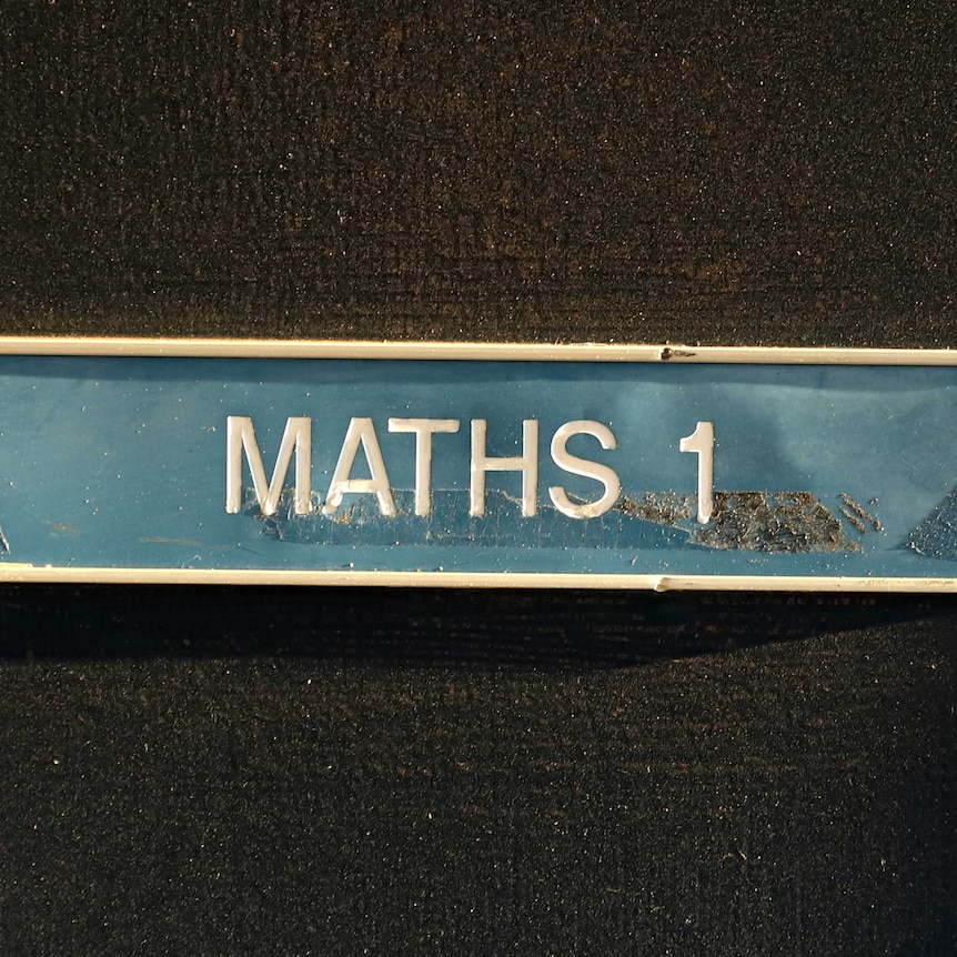 A sign on a door reads Maths 1