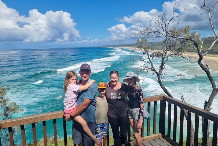 An image of the Mules family on a boardwalk lookout with the coastline in the background