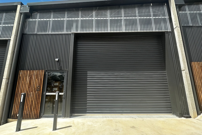 mid-size commerical factory front, big garage door and small door beside it