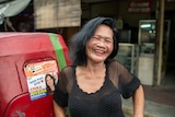 A smiling middle-aged woman in the street