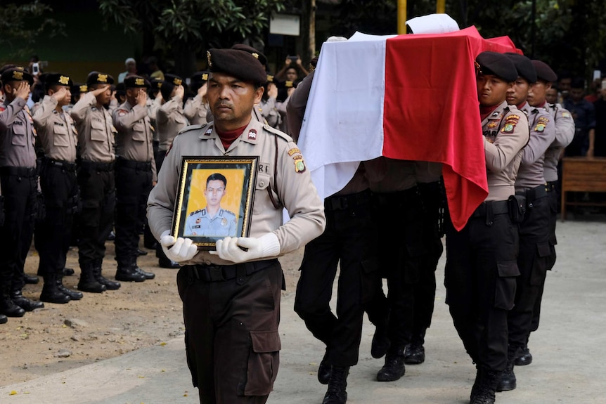 Indonesia policemen carry the coffin of their colleague Imam Gilang Adinata, a victim of a bomb blast in Jakarta.