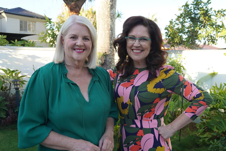 Karen Andrews and Annabel Crabb standing beside each other in a backyard