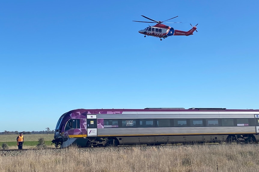 A purple train with a helicopter above