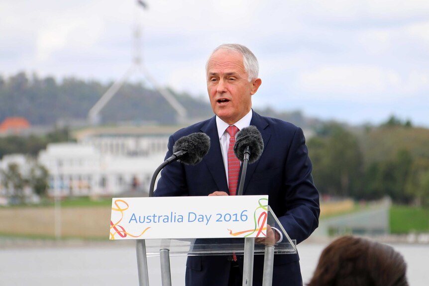 Prime Minister Malcolm Turnbull speaks at a podium with Parliament House, Canberra, out of focus in the distance.