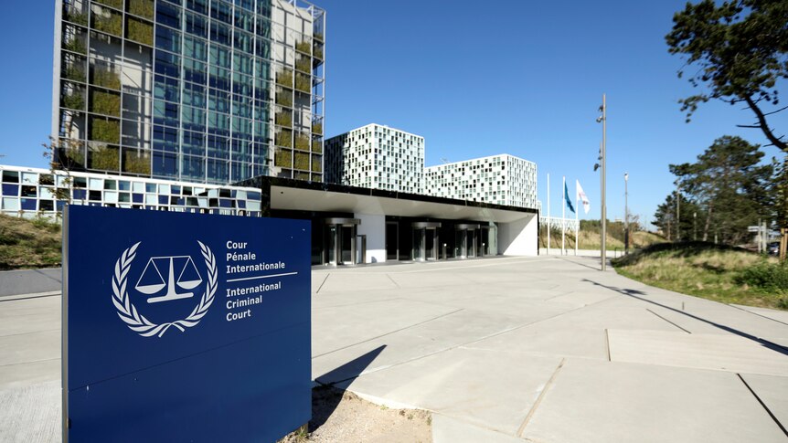 一个蓝色的标牌矗立在路旁，上面标记着国际刑事法院的名称